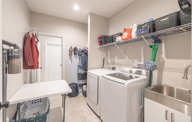 laundry area with sink, light tile patterned floors, cabinets, and separate washer and dryer