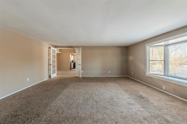 empty room featuring french doors and carpet