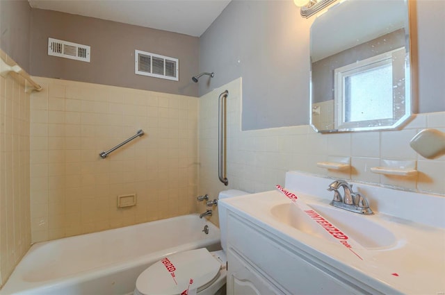 full bathroom with tiled shower / bath combo, vanity, tile walls, and toilet