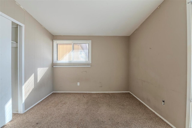 unfurnished bedroom with light colored carpet and a closet