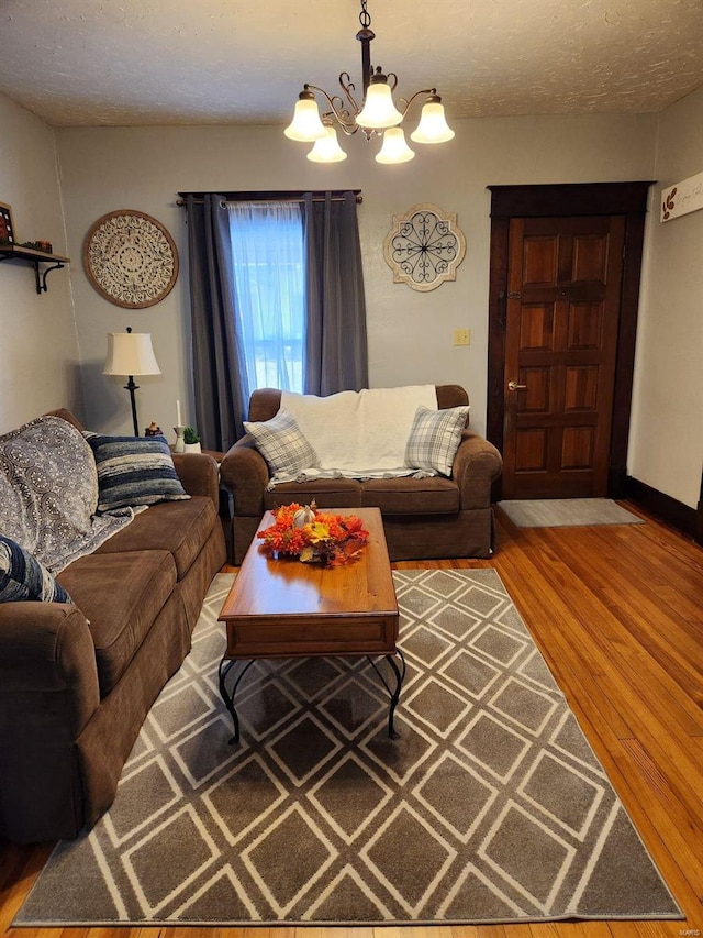 living room with a textured ceiling, an inviting chandelier, and hardwood / wood-style flooring