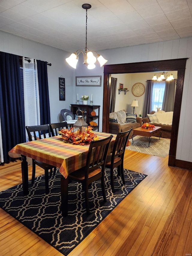 dining room with hardwood / wood-style floors and a notable chandelier