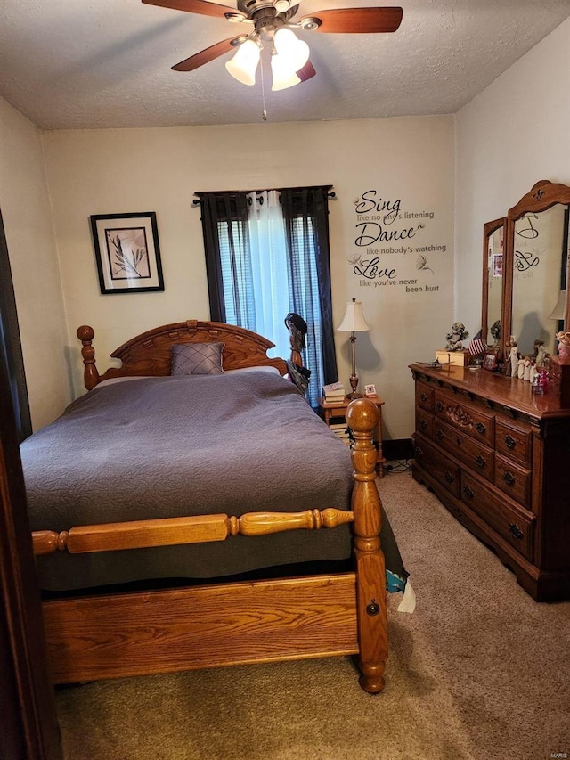 carpeted bedroom featuring ceiling fan and a textured ceiling