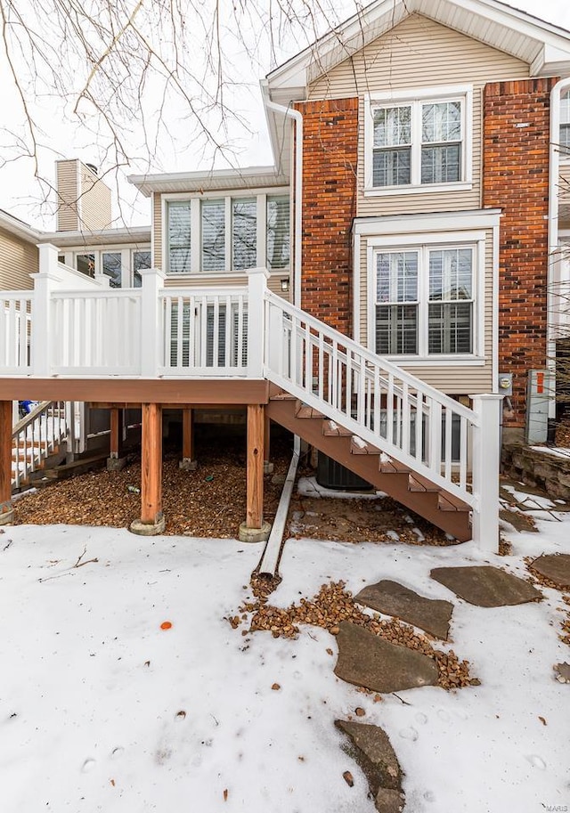 snow covered house with a wooden deck