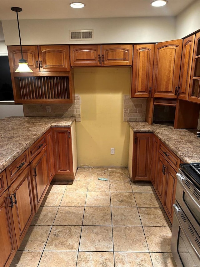 kitchen featuring stainless steel range, light tile patterned floors, pendant lighting, and light stone counters