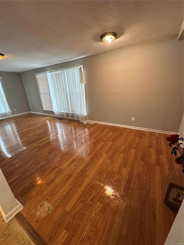 spare room featuring a textured ceiling and wood-type flooring