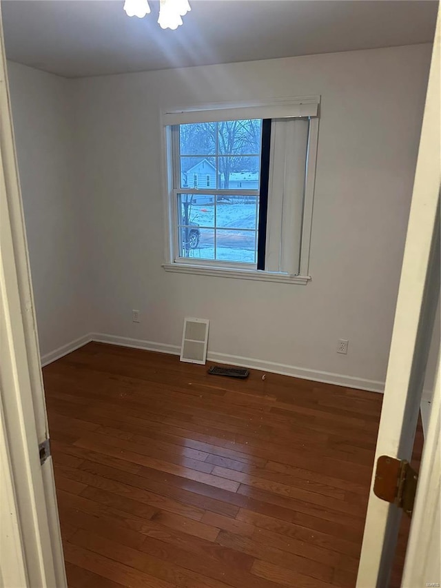 empty room with dark hardwood / wood-style flooring