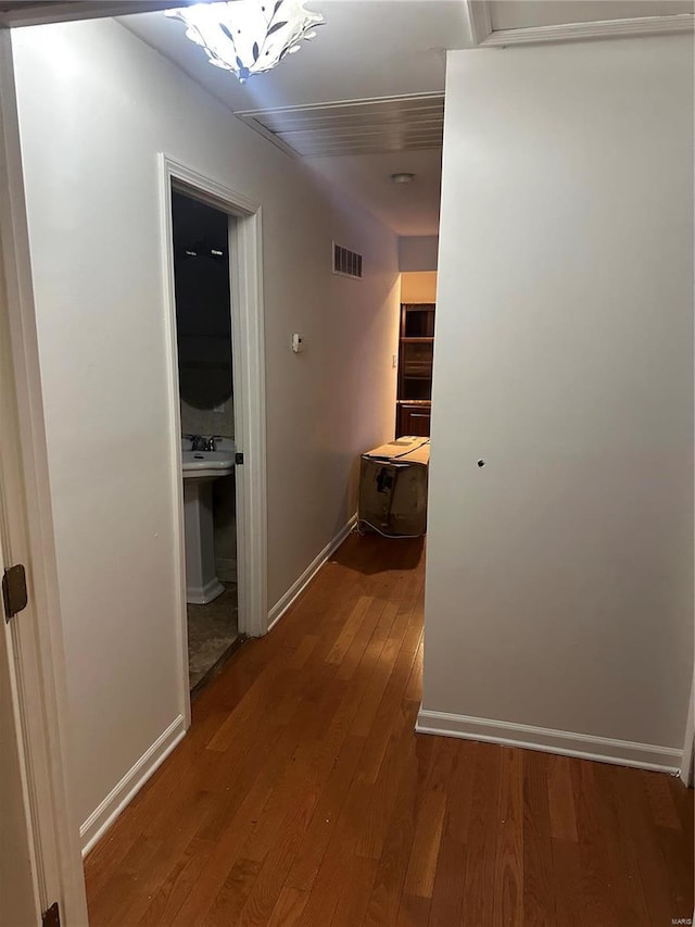 hallway featuring wood-type flooring and sink