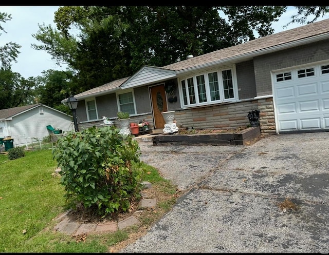 ranch-style home with a garage and a front lawn