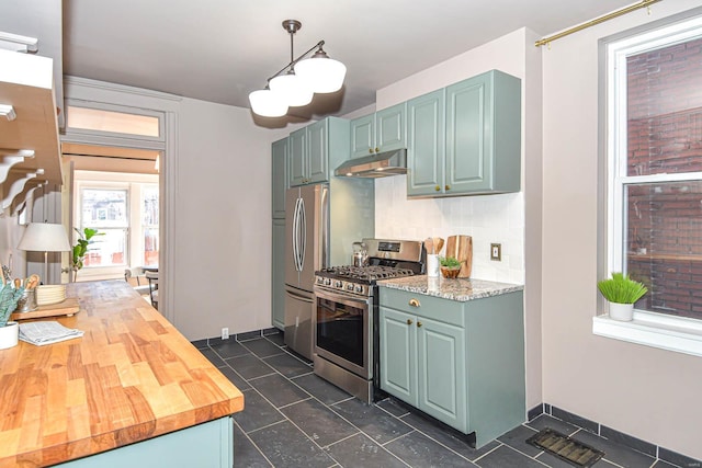 kitchen with butcher block countertops, green cabinets, appliances with stainless steel finishes, backsplash, and decorative light fixtures