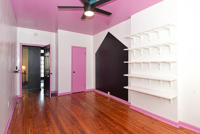 empty room with ceiling fan and dark hardwood / wood-style flooring