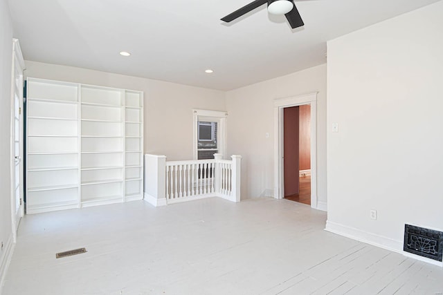 spare room with ceiling fan and light wood-type flooring