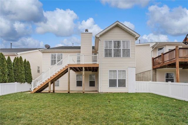 rear view of property featuring a deck and a lawn