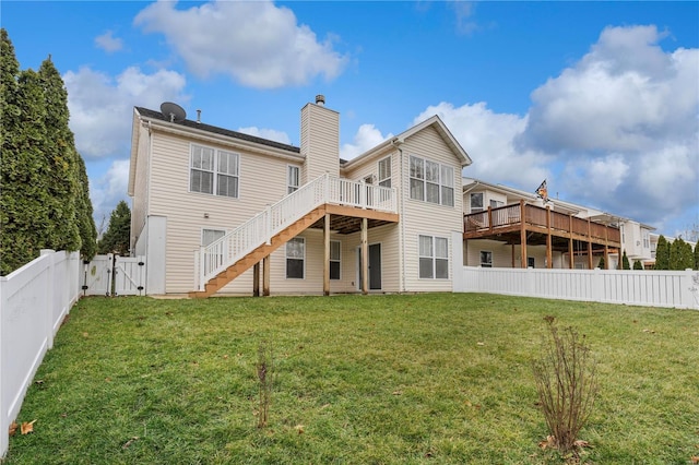 back of property with a wooden deck and a yard