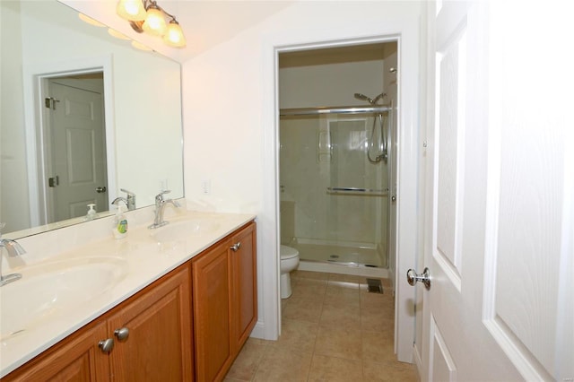 bathroom with tile patterned flooring, vanity, a shower with door, and toilet