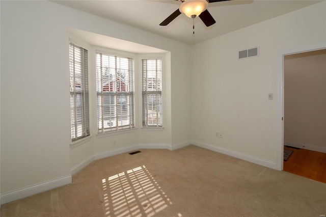 empty room with light colored carpet and ceiling fan