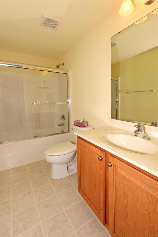 full bathroom featuring vanity, tile patterned floors, toilet, and combined bath / shower with glass door