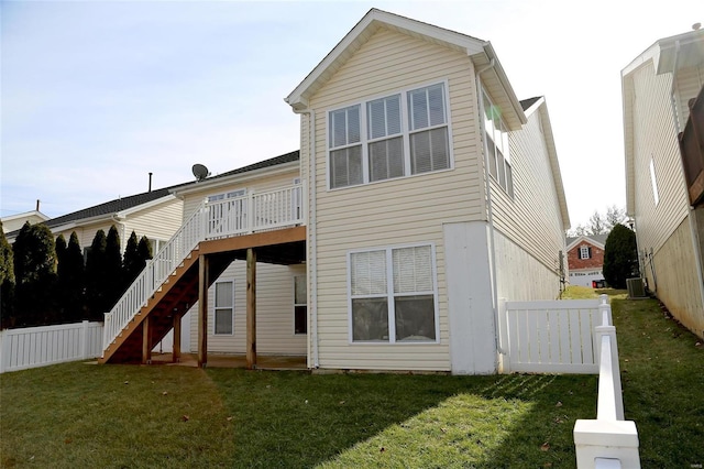 back of house with central AC and a yard