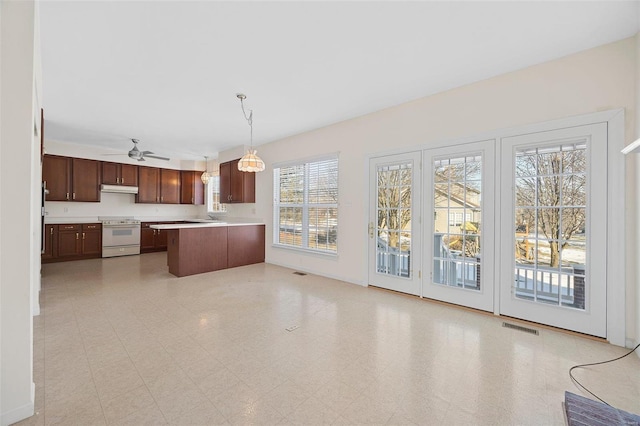 kitchen with light countertops, white electric range, visible vents, open floor plan, and under cabinet range hood