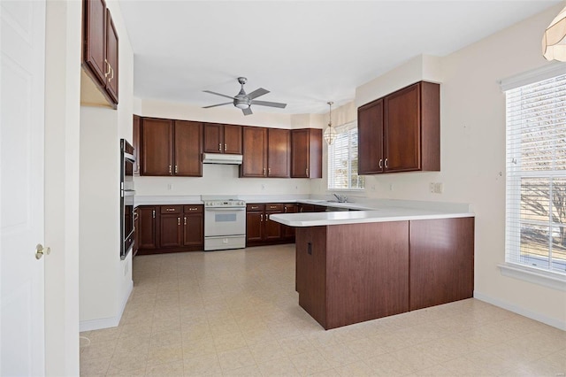 kitchen with a ceiling fan, a peninsula, light floors, and white electric range oven