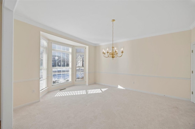 carpeted spare room with a chandelier, baseboards, visible vents, and crown molding