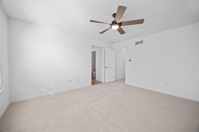 empty room with baseboards, a ceiling fan, visible vents, and light colored carpet