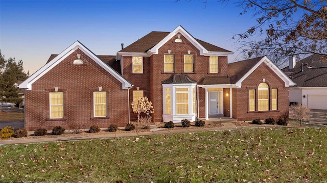 traditional home with brick siding and a front yard