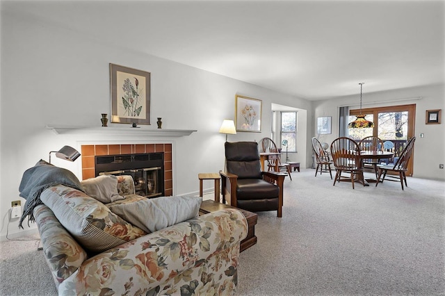 carpeted living room featuring a tiled fireplace