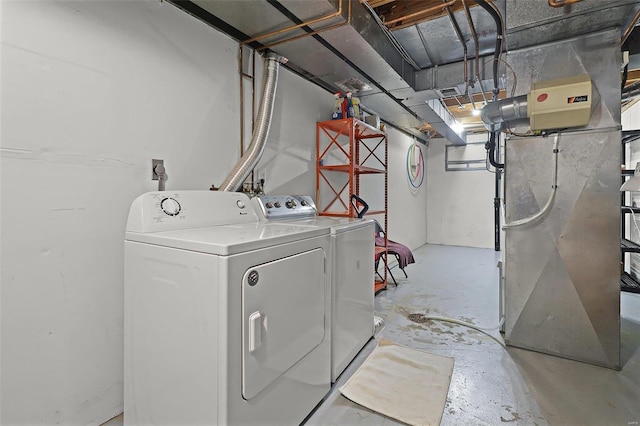 clothes washing area featuring heating unit and washing machine and clothes dryer