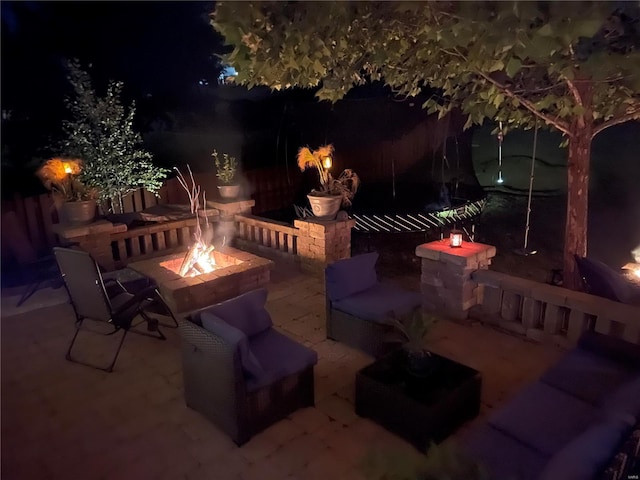 patio at night featuring an outdoor fire pit