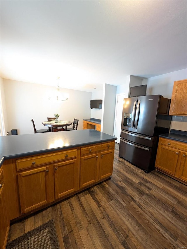 kitchen with decorative light fixtures, stainless steel refrigerator with ice dispenser, and dark hardwood / wood-style floors