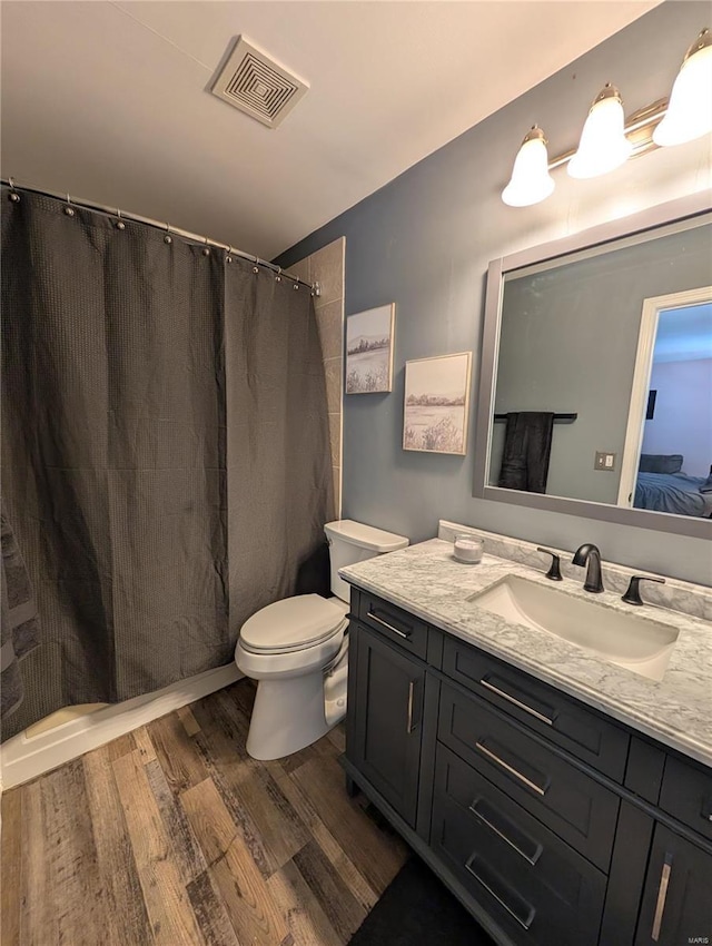 bathroom with hardwood / wood-style flooring, toilet, and vanity