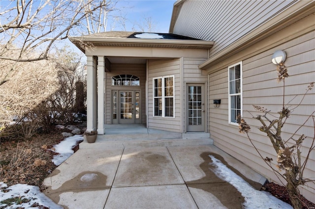 snow covered property entrance with a patio area