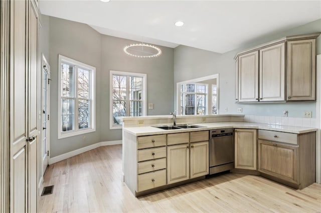 kitchen featuring sink, a wealth of natural light, light hardwood / wood-style floors, and kitchen peninsula