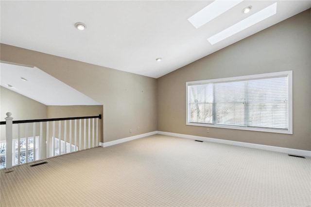 empty room featuring carpet floors and vaulted ceiling with skylight