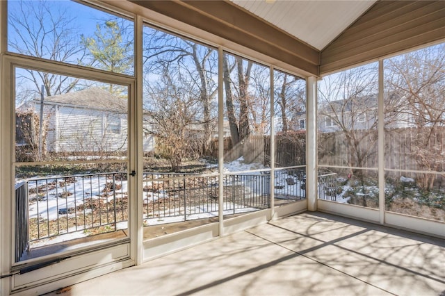 unfurnished sunroom featuring vaulted ceiling