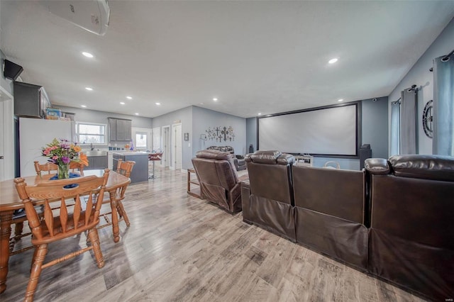 cinema room with sink and light hardwood / wood-style floors