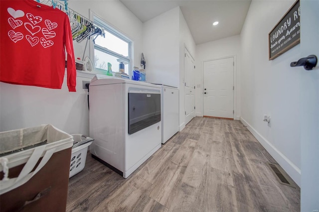 laundry area featuring hardwood / wood-style flooring and washing machine and clothes dryer