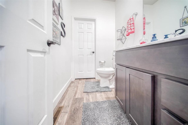 bathroom featuring vanity, hardwood / wood-style floors, and toilet