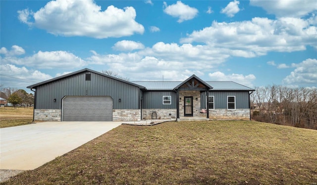 view of front facade with a garage, driveway, stone siding, metal roof, and a front yard