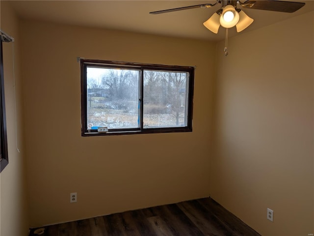 spare room featuring dark wood-type flooring and ceiling fan