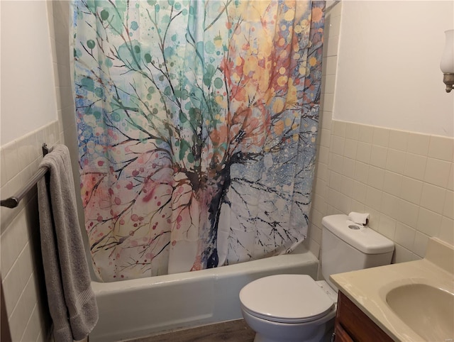 full bathroom with tile walls, vanity, toilet, and shower / bath combo with shower curtain