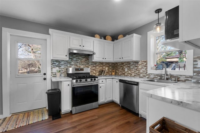 kitchen with sink, white cabinetry, decorative light fixtures, appliances with stainless steel finishes, and dark hardwood / wood-style flooring