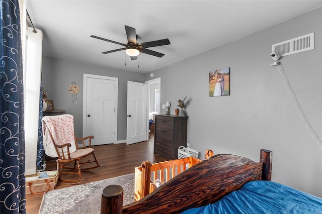 bedroom with dark hardwood / wood-style flooring and ceiling fan