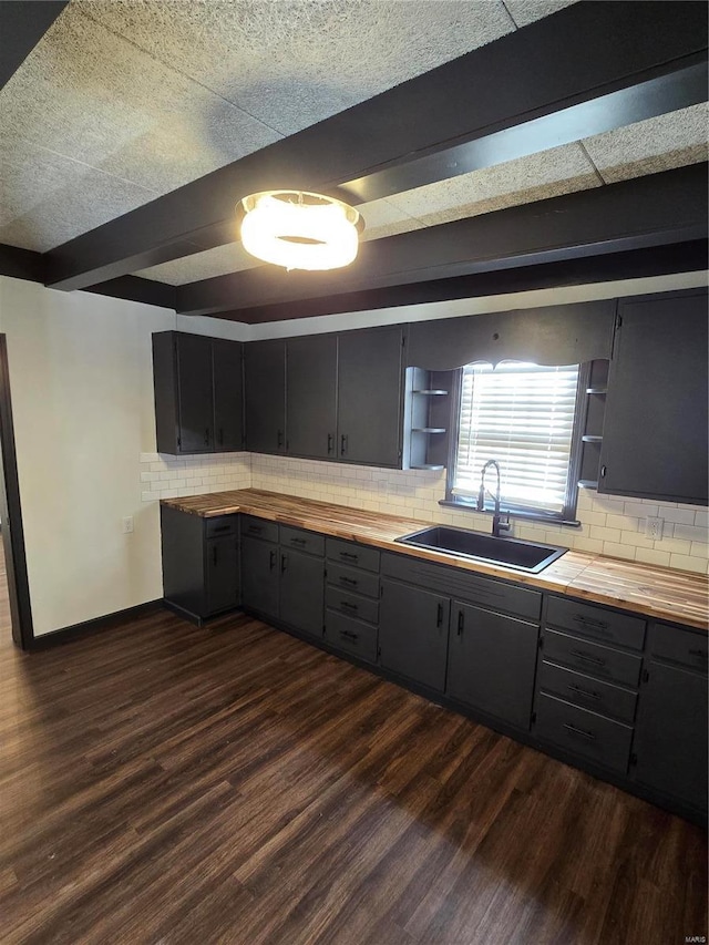 kitchen featuring sink, wooden counters, dark hardwood / wood-style flooring, and decorative backsplash