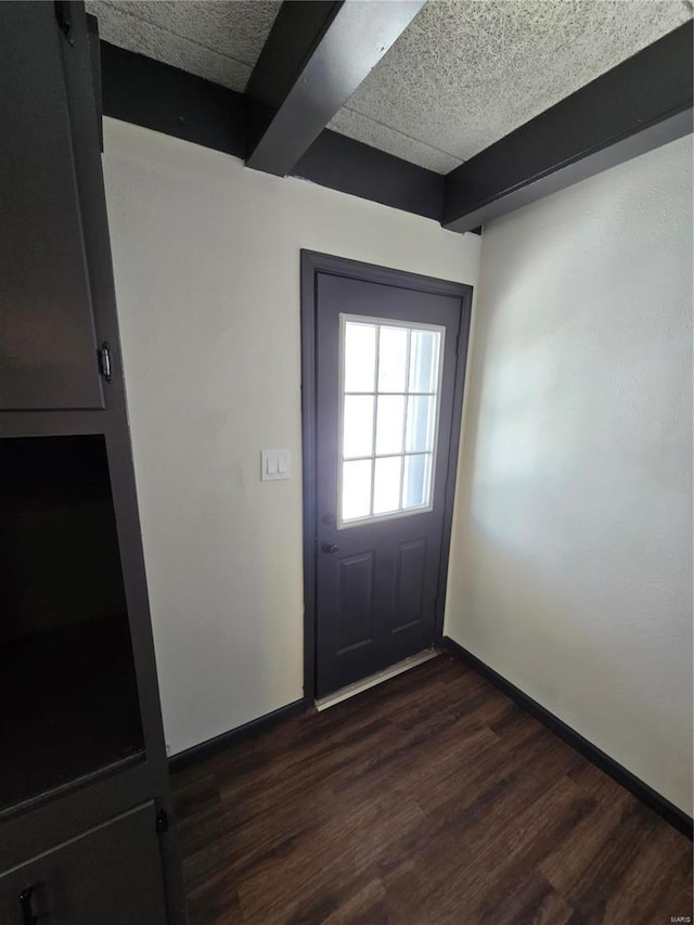 doorway with dark hardwood / wood-style flooring and beam ceiling