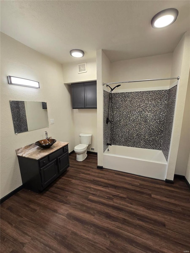 full bathroom featuring vanity, hardwood / wood-style flooring, bathing tub / shower combination, and toilet