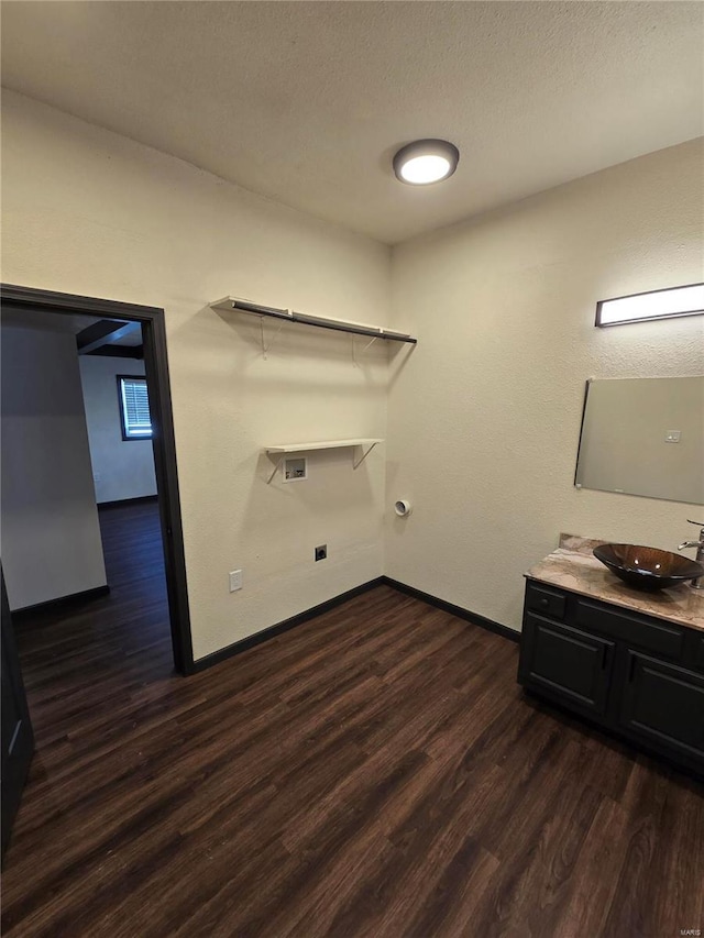 laundry room featuring hookup for a washing machine, sink, dark wood-type flooring, and a textured ceiling