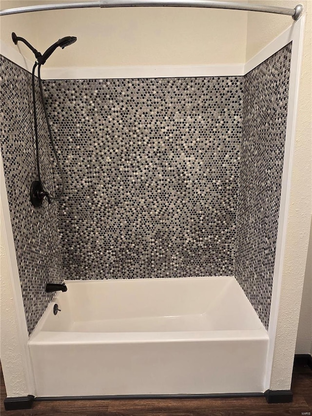 bathroom featuring tiled shower / bath combo and hardwood / wood-style floors