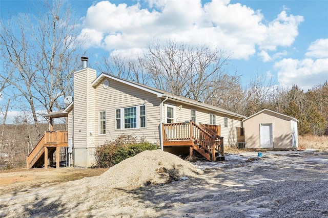 view of front of house with a storage shed and a deck